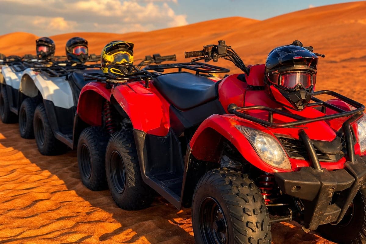 Row of red ATV quad bikes with helmets at start of Dubai desert ride on red sand dunes