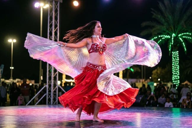Belly dancer with silver wings performing at the desert camp