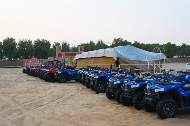 Blue quad bikes lined up for a quad biking session in the Dubai desert