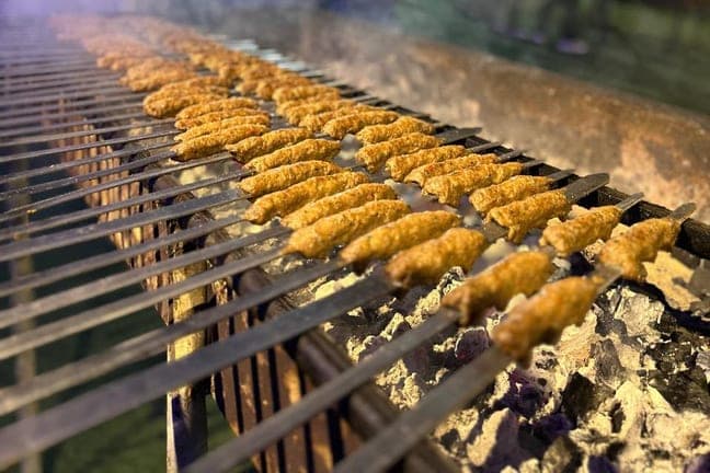 Corn and skewers cooking on the BBQ grill at the desert camp