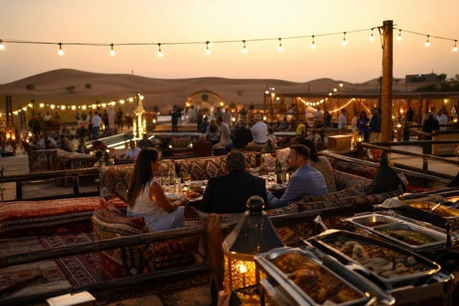 Guests dining in the VIP sofa section of a Dubai premium desert safari camp at dusk