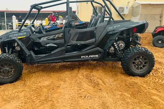 Black Polaris RZR XP 1000 4-seater dune buggy parked at Dubai desert base camp