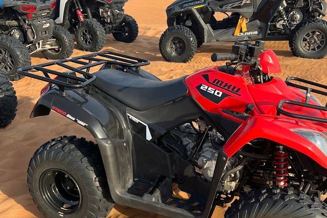 Kymco MXU 250 quad bike and Polaris RZR buggies on Dubai desert sand